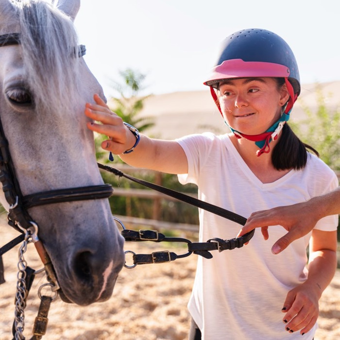 EAAT_5.14.24 Young girl with Downs Syndrome gently pets a white horse